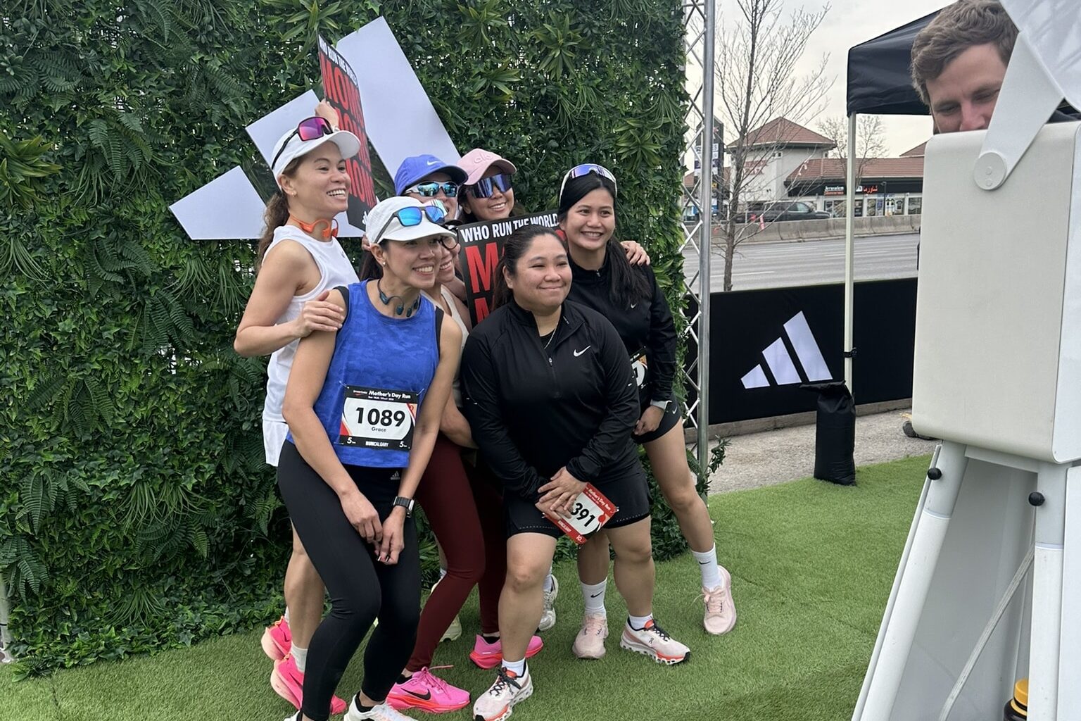 Women posing for a photo with an open air photo booth at an Adidas event